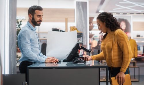 intelligent-edgeware-rfid-retail-checkout Retail associate using an RFID-enabled checkout powered by intelligent edgeware